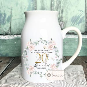 May include: White ceramic mug with a floral design and gold lettering. The mug says "On your China Wedding Anniversary 20th Mum & Dad 2005-2025".
