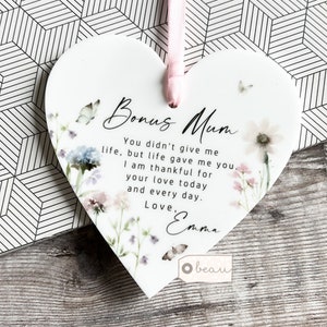 May include: White ceramic heart-shaped ornament with a floral design and the text "Bonus Mum You didn't give me life, but life gave me you. I am thankful for your love today and every day. Love, Emma"