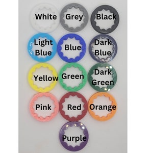 Op de afbeelding: Assortiment van 12 kleurrijke plastic ringen met gegolfde randen. De ringen zijn gelabeld met de volgende kleuren: wit, grijs, zwart, lichtblauw, blauw, donkerblauw, geel, groen, donkergroen, roze, rood, oranje en paars.