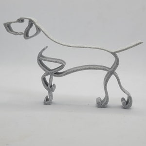 May include: A white, 3D printed, wire-frame sculpture of a dog standing on all four legs. The sculpture is made of a single continuous piece of wire.