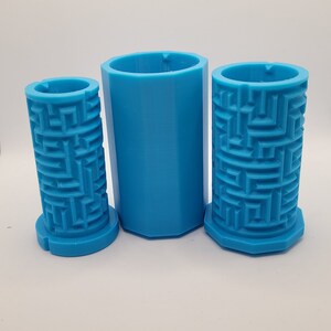 Op de afbeelding: Drie blauwe plastic mallen voor het maken van betonnen plantenbakken. De mallen zijn cilindrisch en hebben een textuurpatroon van een doolhof aan de buitenkant.