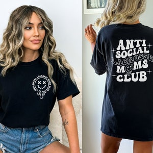 May include: Black t-shirt with a white graphic that says "Anti-Social Lacrosse Moms Club" and a dripping smiley face with X's for eyes.