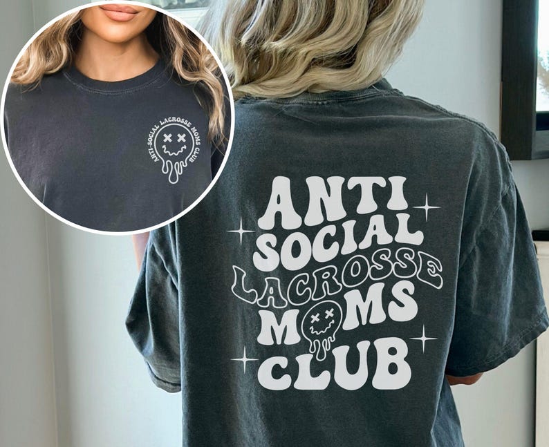 May include: A dark gray t-shirt with a white graphic that says "Anti Social Lacrosse Moms Club" in a retro font. The graphic includes a dripping smiley face with X's for eyes.