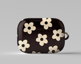 May include: A black Airpods case with a white daisy pattern.
