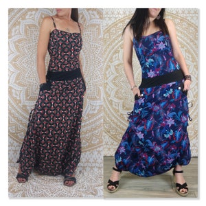 Peut inclure: Deux femmes portant de longues robes fluides avec des motifs différents. La robe de gauche a un motif géométrique en noir, rouge et blanc. La robe de droite a un motif floral en bleu, rose et blanc. Les deux robes ont une ceinture noire et des poches.