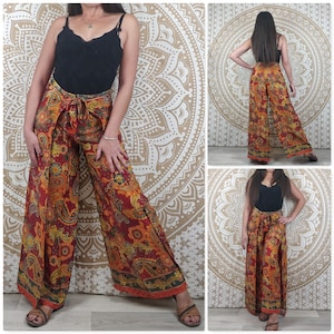 Op de afbeelding: Een wijde broek met paisley print in tinten rood, oranje en geel. De broek heeft een wikkel-stijl en een strik in de taille.