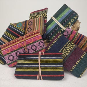 Puede incluir: Una colección de bolsas de tela tejidas de colores con patrones geométricos. Las bolsas están hechas de una variedad de materiales, incluyendo algodón y seda. Son perfectas para guardar objetos pequeños, como joyas, monedas o llaves.