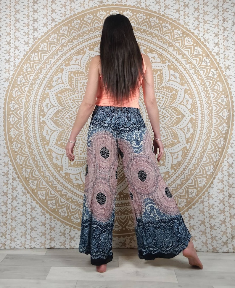 Puede incluir: Pantalones de pierna ancha con un estampado circular rosa y azul marino. Los pantalones tienen un borde decorativo y se combinan con una camiseta sin mangas color melocot&oacute;n. El fondo presenta un tapiz de mandala dorado.