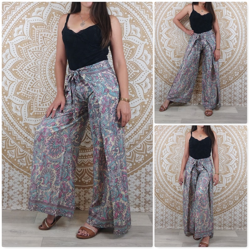 Op de afbeelding: Een wijde broek met paisley print in roze, blauwe en witte tinten. De broek heeft een wikkel-stijl en wordt in de taille vastgebonden met een band.