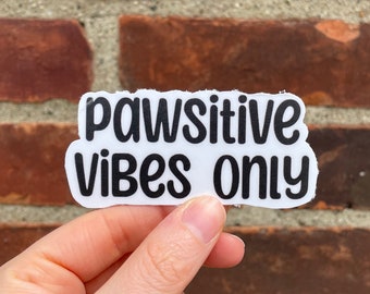 May include: White sticker with black text that reads "Pawsitive Vibes Only".