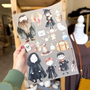 Può includere: Un foglio di adesivi con illustrazioni ad acquerello di personaggi e oggetti dell'universo di Harry Potter. Gli adesivi includono una fenice, un elfo domestico, un mago, una strega, una valigia, una scopa e una creatura magica.