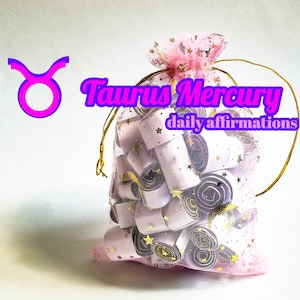 Puede incluir: Una bolsa de malla rosa llena de pequeños papeles enrollados blancos y morados con estrellas doradas impresas en ellos. La bolsa tiene un cordón de ajuste dorado y el texto "Taurus Mercury daily affirmations" está impreso en la parte delantera.