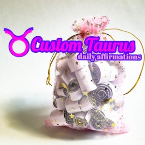 Puede incluir: Una bolsa de malla rosa con cordón de ajuste dorado llena de papel blanco enrollado con estrellas doradas impresas en él. La bolsa tiene el texto "Custom Taurus daily affirmations" impreso en ella.