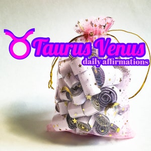 Puede incluir: Una bolsa de malla rosa llena de pequeños papeles enrollados blancos y morados con estrellas doradas impresas en ellos. La bolsa tiene un cordón de ajuste dorado y el texto "Taurus Venus daily affirmations" está impreso en rosa sobre un fondo blanco.