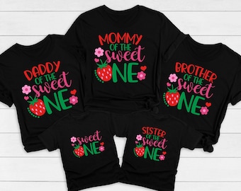 May include: Set of five black t-shirts with a strawberry and text design. The shirts say "Mommy of the Sweet One", "Daddy of the Sweet One", "Brother of the Sweet One", "Sister of the Sweet One", and "Sweet One".