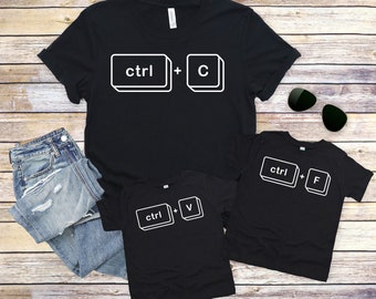 May include: Three black t-shirts with white text and images of computer keyboard keys. The shirts have the text "ctrl + C", "ctrl + V", and "ctrl + F" printed on them.