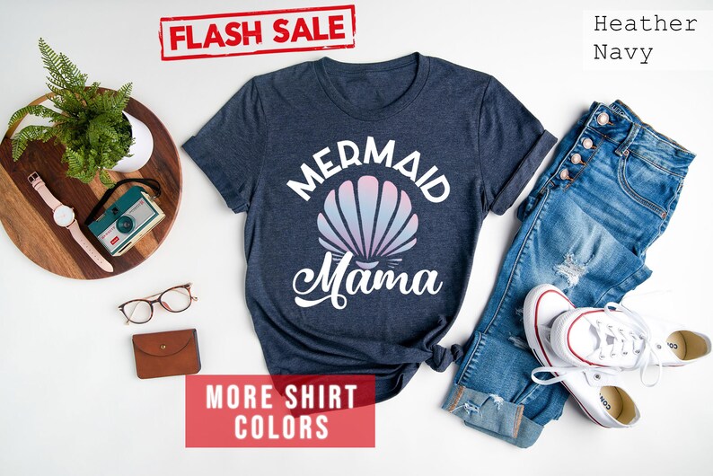 May include: A heather navy blue t-shirt with a white graphic of a seashell and the text "Mermaid Mama".