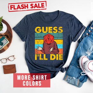 May include: A heather navy blue t-shirt with a vintage-style graphic of a person with a dice for a head. The text "Guess I'll Die" is printed below the graphic.