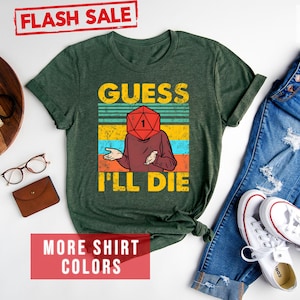 May include: A forest green t-shirt with a vintage-style graphic of a person with a dice for a head. The text on the shirt reads "Guess I'll Die".