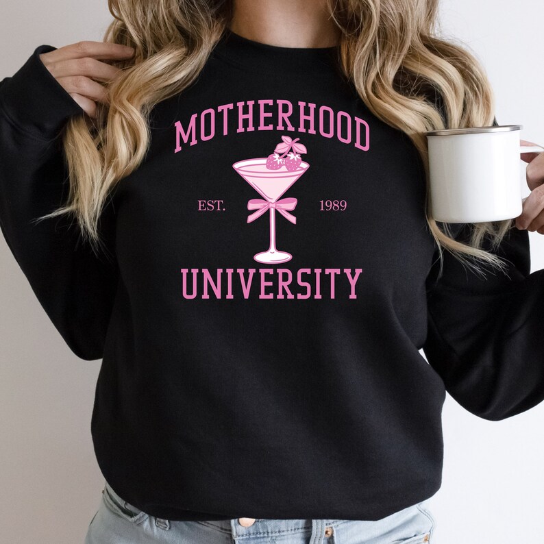 May include: Black sweatshirt with pink text that reads "MOTHERHOOD UNIVERSITY EST. 1989" and a pink martini glass with pink berries on top.