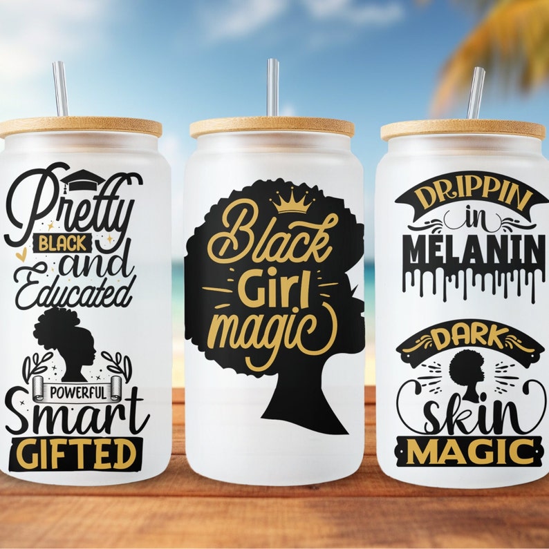 May include: Three white tumblers with black and gold designs. The first tumbler says "Pretty Black and Educated" with a crown and the words "Powerful Smart Gifted". The second tumbler says "Black Girl Magic" with a crown and a silhouette of a woman's head. The third tumbler says "Drippin in Melanin" with a crown and the words "Dark Skin Magic".