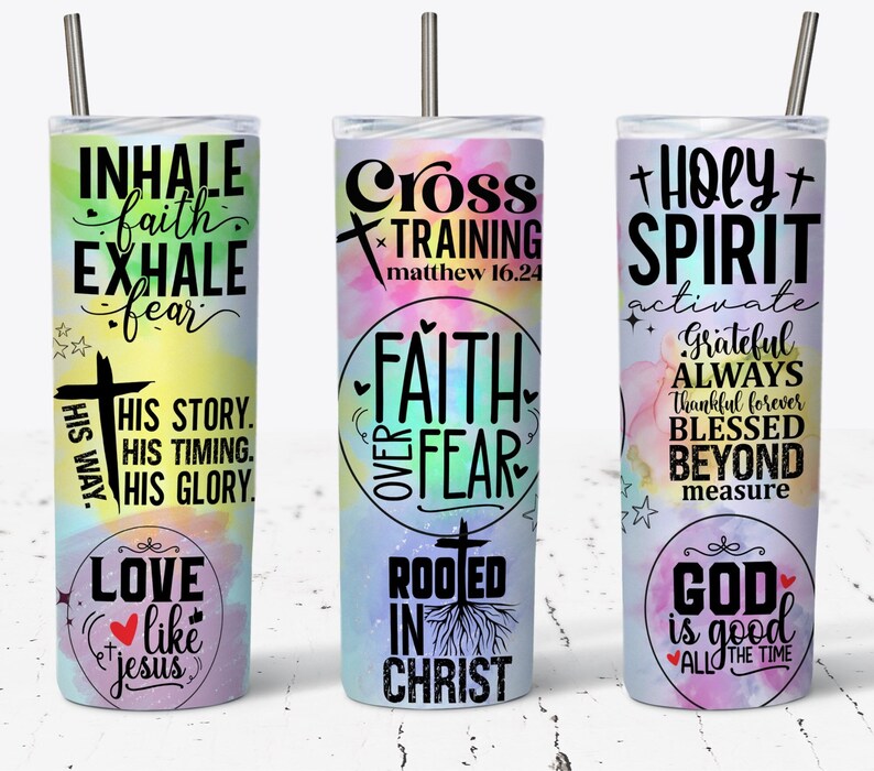 May include: Three stainless steel tumblers with colorful watercolor backgrounds and inspirational Christian quotes. The first tumbler says "Inhale faith, exhale fear" and "His way, His story, His timing, His glory." The second tumbler says "Cross Training Matthew 16:24" and "Faith over Fear." The third tumbler says "Holy Spirit activate" and "Grateful Always Thankful Forever Blessed Beyond Measure."