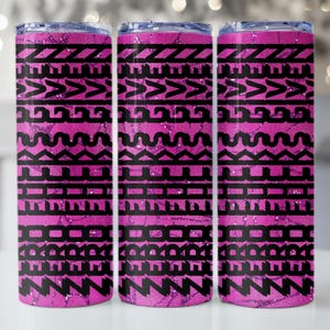May include: Three stainless steel tumblers with a pink and black geometric pattern. The tumblers have a shiny, glittery finish and a black tribal design. The design is repeated on each tumbler.