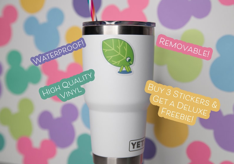 May include: A white Yeti tumbler with a green leaf sticker. The sticker is on the front of the tumbler. Text on the image includes "Waterproof!", "High Quality Vinyl", and "Removable!". The background has colorful Mickey Mouse shapes.