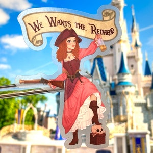 Puede incluir: Una pegatina con una mujer pirata de dibujos animados con el pelo rojo que sostiene una botella y un arma. La pegatina tiene una pancarta que dice "We Wants the Redhead".