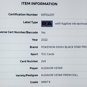 May include: A close-up of a graded trading card for the Pokemon Kleavor VSTAR from the Sword & Shield Black Star Promo set. The card is graded MINT 9 by PSA, a third-party grading company. The card is from 2022 and has a certification number of 69704337.