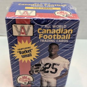 May include: A box of 110 All World Canadian Football trading cards featuring "Rocket" Ismail. The box is blue and red with a picture of Ismail wearing a white jersey with the number 25 on it.