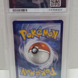 May include: A Pokemon trading card graded by PSA with a blue background and a Pokeball graphic. The card has a PSA 69704337 grading label.