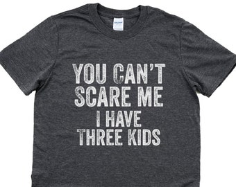 May include: Dark heather grey t-shirt with a distressed white graphic that reads "You can't scare me I have three kids".