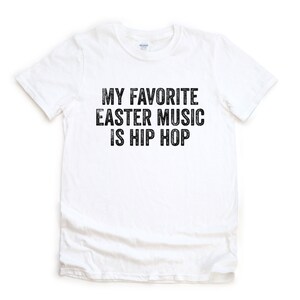 May include: White t-shirt with black text that reads "My favorite Easter music is hip hop."