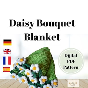 Puede incluir: Una manta verde tejida a ganchillo con flores de margarita blancas y amarillas. La manta está doblada y se muestra sobre una superficie de madera. El texto "Daisy Bouquet Blanket" y "Digital PDF Pattern" es visible.