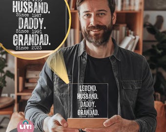 May include: A clear acrylic LED light with the words "LEGEND, HUSBAND, DADDY, GRANDAD" and corresponding years printed in white. The light sits on a wooden base and is held by a person. The word "CUSTOM" is at the bottom.