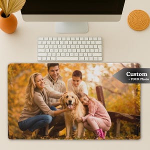May include: Custom photo mouse pad featuring a family with a golden retriever dog in an autumn setting. The mouse pad has a rectangular shape and the text "Custom • YOUR Photo" in a black arrow.