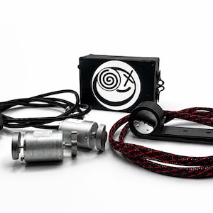 May include: A black rectangular control box featuring a white circular logo with a spiral and an X, two silver cylindrical motors, a black USB cable, and a black mounting bracket attached to a braided red and black cable for electronic assembly.