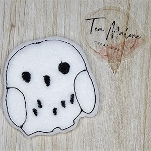 May include: White felt owl applique with black embroidered eyes and details.
