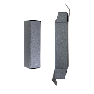 Puede incluir: Dos cajas de cartón grises, una está cerrada y la otra está abierta con la solapa superior doblada hacia atrás.