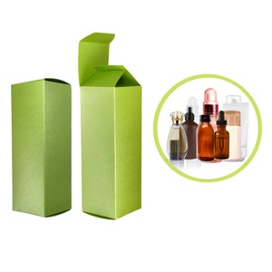 May include: Two green rectangular product boxes, one closed and one open, with a group of cosmetic bottles in a green circle. The boxes have a textured, metallic finish. The open box shows the interior. The bottles include perfume, serum, and lotion containers.