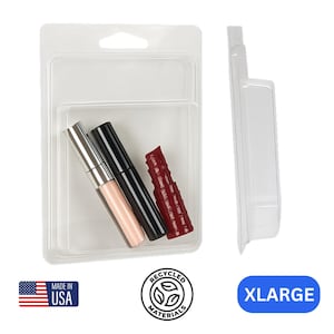 May include: Clear plastic packaging containing three cosmetic products: a silver and pink tube, a black tube, and a dark red lipstick. The packaging includes the text "MADE IN USA" and "RECYCLED MATERIALS". The label reads "XLARGE".