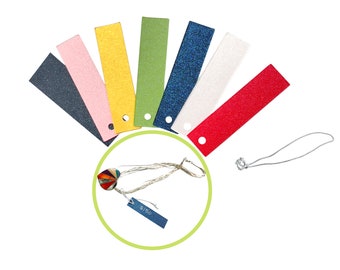 May include: A set of ten colorful paper tags with a hole punched in each. The tags are arranged in a fan shape with the colors: navy blue, pink, yellow, green, blue glitter, white, red glitter. A silver cord with a silver clasp is also included.
