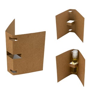 May include: Cardboard packaging with cut-out sections. One piece is folded into a box shape, another has shelves, and a third holds a small glass bottle with a white cap. The packaging is made of brown cardboard.