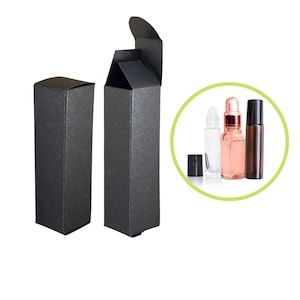May include: Two black cardboard boxes with a textured surface. One box is open and the other is closed. The boxes are designed to hold small bottles of essential oils or other liquids.