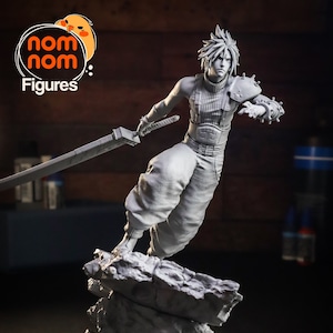 Peut inclure: Figurine grise d'un personnage de Final Fantasy, posant avec une grande épée. La figurine est posée sur une base rocheuse. Le logo "nom nom Figures" est dans le coin supérieur gauche.