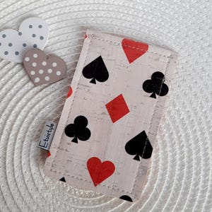 May include: A light pink card holder with a playing card design featuring red hearts and diamonds, and black clubs and spades. The card holder is made of a cork-like material and has the text "Etwistyle".