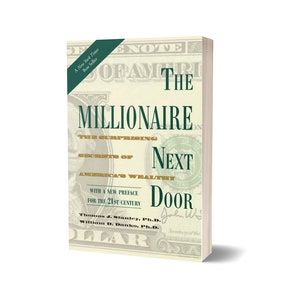 Peut inclure: Un livre à couverture rigide intitulé "The Millionaire Next Door" avec une bannière New York Times Best Seller. La couverture présente des images de billets de banque et du texte sur les secrets des riches américains. Les noms des auteurs sont également visibles.