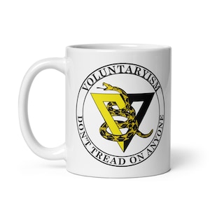 May include: White ceramic mug with a black and yellow graphic of a snake wrapped around a triangle with the text "VOLUNTARYISM DON'T TREAD ON ANYONE".