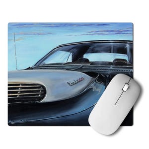 May include: A black and silver vintage car with a chrome grille and the word "Supercar" written on the hood. The car is set against a blue sky with white clouds. A white computer mouse is in the foreground.